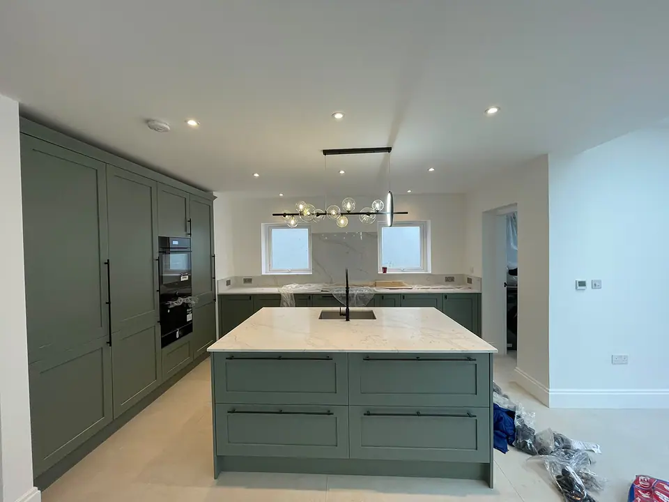 Sage green shaker kitchen with a marble-effect island